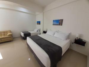 ein Hotelzimmer mit einem großen Bett und einem Sofa in der Unterkunft Hotel El Marqués De Manga in Cartagena de Indias