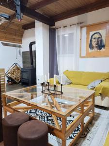 sala de estar con mesa y sofá amarillo en Stay Wild, en Žabljak