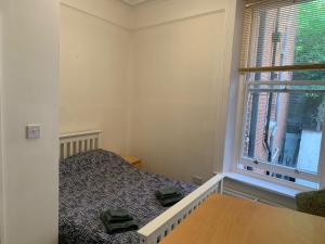 um pequeno quarto com uma cama e uma janela em Beachfront Apartment with BBQ Sun Deck em Bournemouth