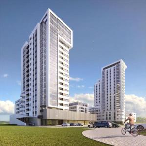 mężczyzna jeżdżący na rowerze przed dwoma wysokimi budynkami w obiekcie Apartament Aquatower w Redzie