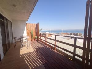 a balcony with a table and a view of the beach at Loft Tongoy 1 frente al mar in Coquimbo