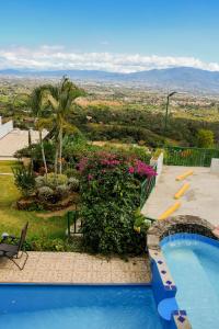 a swimming pool with a view from a house at Loma Tranquila in Alajuela City