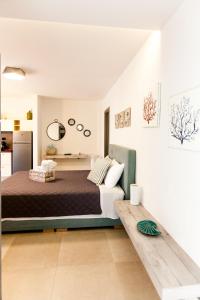 - une chambre blanche avec un lit et un canapé dans l'établissement Nafplio Small Apartment - II, à Nauplie