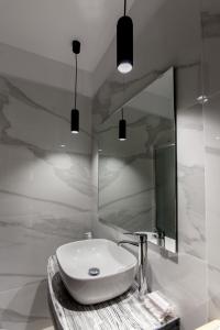 La salle de bains est pourvue d'un lavabo et d'un miroir. dans l'établissement Nafplio Small Apartment - II, à Nauplie