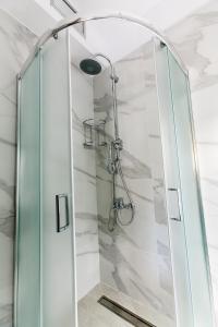 La salle de bains est pourvue d'une douche avec une porte en verre. dans l'établissement Nafplio Small Apartment - II, à Nauplie