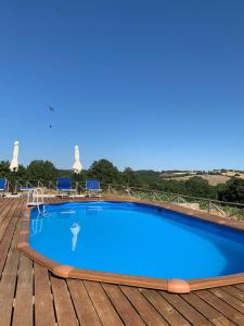 a large blue swimming pool on a wooden deck at Podere Cerciano in Radicondoli