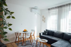 ein Wohnzimmer mit einer Couch und einem Tisch und Stühlen in der Unterkunft Apartman Vas dom in Kraljevo