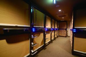 a hallway of a train with blue lights on it at Anshin Oyado Tokyo Akihabara Denkigaiten- Male Only in Tokyo