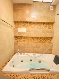 a bath tub in a bathroom with a tiled wall at Arcadia Terrace Sea Breeze in Odesa +12 photos