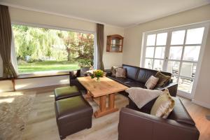 uma sala de estar com um sofá e uma mesa em Landhaus Hideaway mit Aussenpool, Sauna und Kamin em Bosau