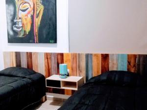um quarto com duas camas e um quadro na parede em Departamento Retro pv em Puerto Vallarta