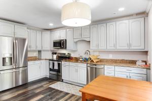 a kitchen with white cabinets and a wooden table at Pine Whiff Gardens in Annapolis