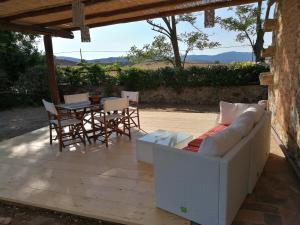 a patio with a couch and a table and chairs at Affitti Brevi Toscana - Ospitalità in Campagna in Talamone