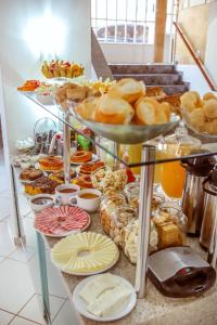 a buffet of pastries and donuts on a table at Pousada Souza Reis in São Thomé das Letras