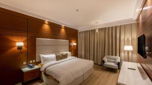 um quarto de hotel com uma cama e uma cadeira em فندق فلافور Flavor Hotel em Medina