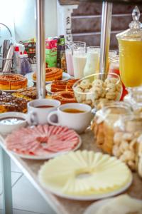 a table filled with plates of food and drinks at Pousada Souza Reis in São Thomé das Letras