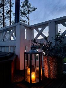 a lantern sitting on a porch with candles in a basket at Maja Luxury Glamping Suites in Mäntyharju