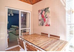 uma sala de jantar com uma mesa e um quadro na parede em Apartamento Top em Itaguá em Ubatuba