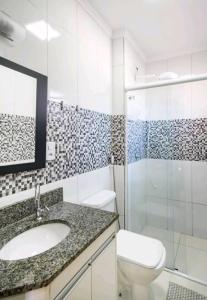 uma casa de banho com um lavatório, um WC e um chuveiro em Apartamento Top em Itaguá em Ubatuba