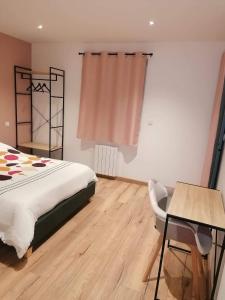 Chambre privative avec spa في Louplande: غرفة نوم بسرير وطاولة وكرسي