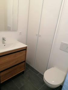 y baño con lavabo blanco y aseo. en Chambre privative avec spa en Louplande