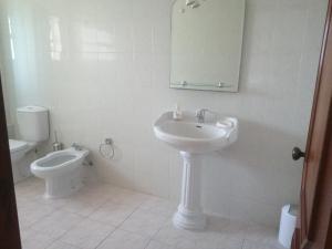 Un baño blanco con lavabo e inodoro. en T1 em Alvor, en Alvor