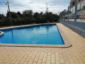 Una gran piscina azul al lado de un edificio en T1 em Alvor, en Alvor