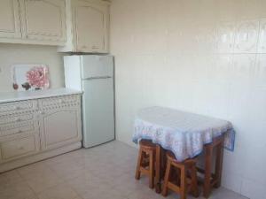 Una cocina con una mesa y un refrigerador blanco. en T1 em Alvor, en Alvor 5 fotos más