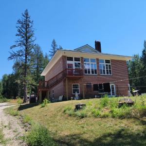 a large brick house on a grassy hill at The Colburn Schoolhouse - Literature Suite in Sandpoint