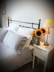 a bed with white pillows and a table with a lamp at Hebble End View B&B in Hebden Bridge