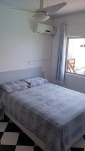 a bedroom with a large bed with a window at Residencial di Raffaele em Bombinhas in Bombinhas