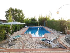una piscina con due sedie e un ombrellone di CERSETO 2 a Santa Domenica Talao