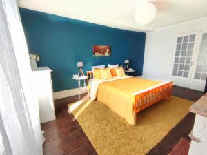 a bedroom with a bed with a blue wall at Number 22 - Le Dorat - Apartment 4 with garden & free parking in Le Dorat