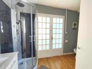 uma casa de banho com um chuveiro e uma porta de vidro em Number 22 - Le Dorat - Apartment 4 em Le Dorat