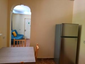 a kitchen with a table and a refrigerator at Hotel Salosi in Tbilisi City