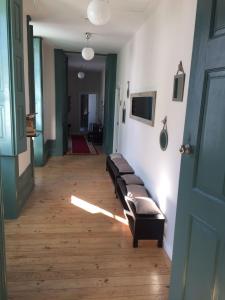 un couloir avec une ligne de bancs dans une pièce dans l'établissement Ilha 12 Suites, à Coimbra