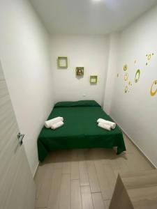 カステッランマーレ・デル・ゴルフォにあるCasa fragolaの白い部屋の緑のベッド1台(タオル2枚付)
