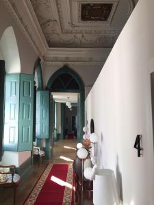 a hallway with a ceiling and a room with a red rug at Ilha 12 Suites in Coimbra
