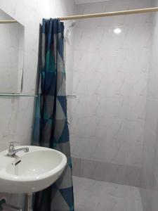 y baño con lavabo y ducha. en Delta Charlie Staycation CDO, en Cagayan de Oro