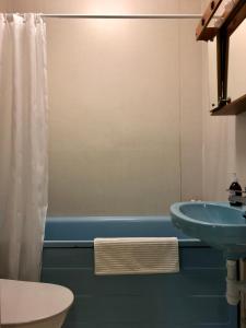 y baño con lavabo y bañera azul. en Borgviks herrgårdsflygel, en Borgvik