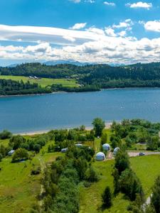 an aerial view of a lake with tents and trees at Czorsztyn Glamp in Maniowy