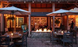 um pátio com mesas e guarda-sóis e uma fogueira em The Monte Vista Hotel em Black Mountain