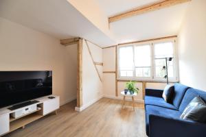 a living room with a blue couch and a tv at Das schiefe Haus Wohnung Bergstraße in Heppenheim an der Bergstrasse