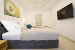 - une chambre avec un grand lit et des oreillers blancs dans l'établissement Luxury Saarbrücken 2, à Sarrebruck