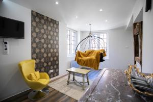 - un salon avec une chaise et une balançoire dans l'établissement Appartement de la noblesse - designed by C.M, à Sélestat