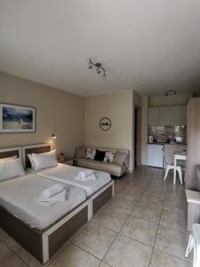 a bedroom with a bed and a couch and a kitchen at DeniaStella villas in Skala Potamias