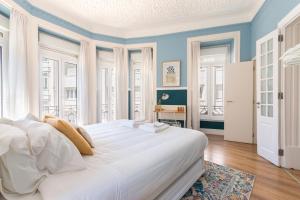 1 cama blanca grande en una habitación con ventanas en Bright City Center, 10m from subway, 6 rooms, up to 20 PPL, en Lisboa
