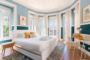 Un dormitorio con una cama blanca con paredes y ventanas azules en Bright City Center, 10m from subway, 6 rooms, up to 20 PPL, en Lisboa
