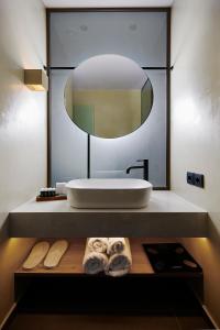 a bathroom with a sink and a large mirror at Mare Suites in Lékhaion