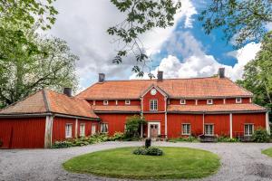 una casa roja con techo rojo en Borgviks herrgårdsflygel, en Borgvik